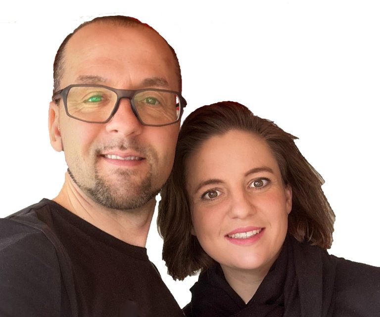 Ein Mann und eine Frau lächeln in die Kamera, beide tragen legere Kleidung.