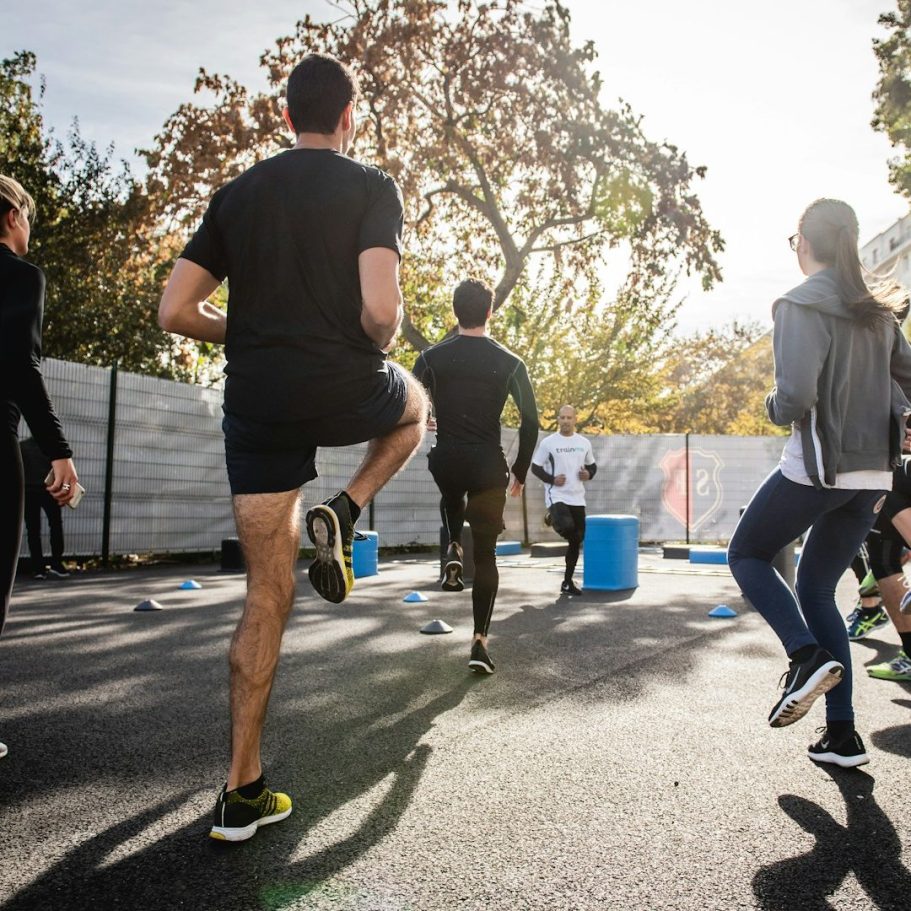 Sport im BGM Gruppentraining im Freien mit aktiven Teilnehmern, die Übungen durchführen.